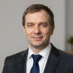 Портрет уверенного российского бизнесмена с дружелюбным взглядом на размытом нейтральном фоне в студии