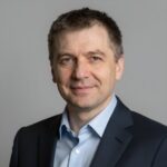 Портрет уверенного российского бизнесмена с дружелюбным взглядом на размытом нейтральном фоне в студии